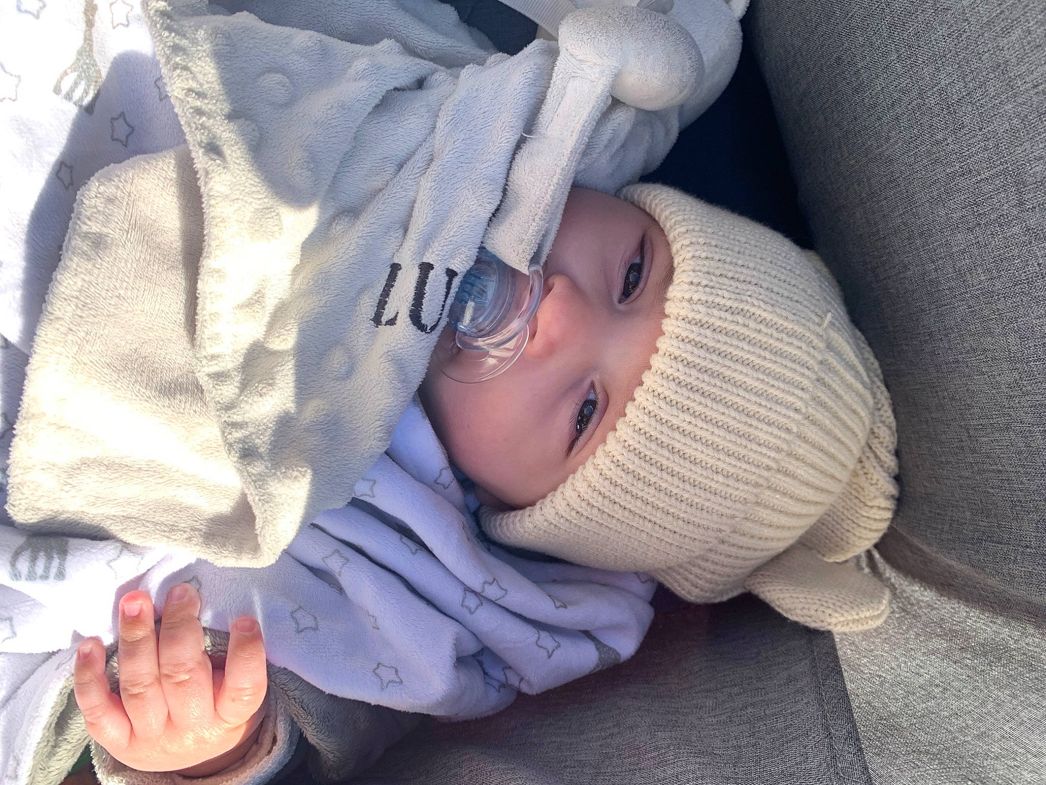 Lucenzo participe au concours pour gagner de l'argent avec cette photo : baby, baby_products, baby_toddler_clothing, cap, child, comfort, eye, finger, gesture, happy, hat, headwear, person, product, sitting, skin, sleeve, smile, thumb, toddler