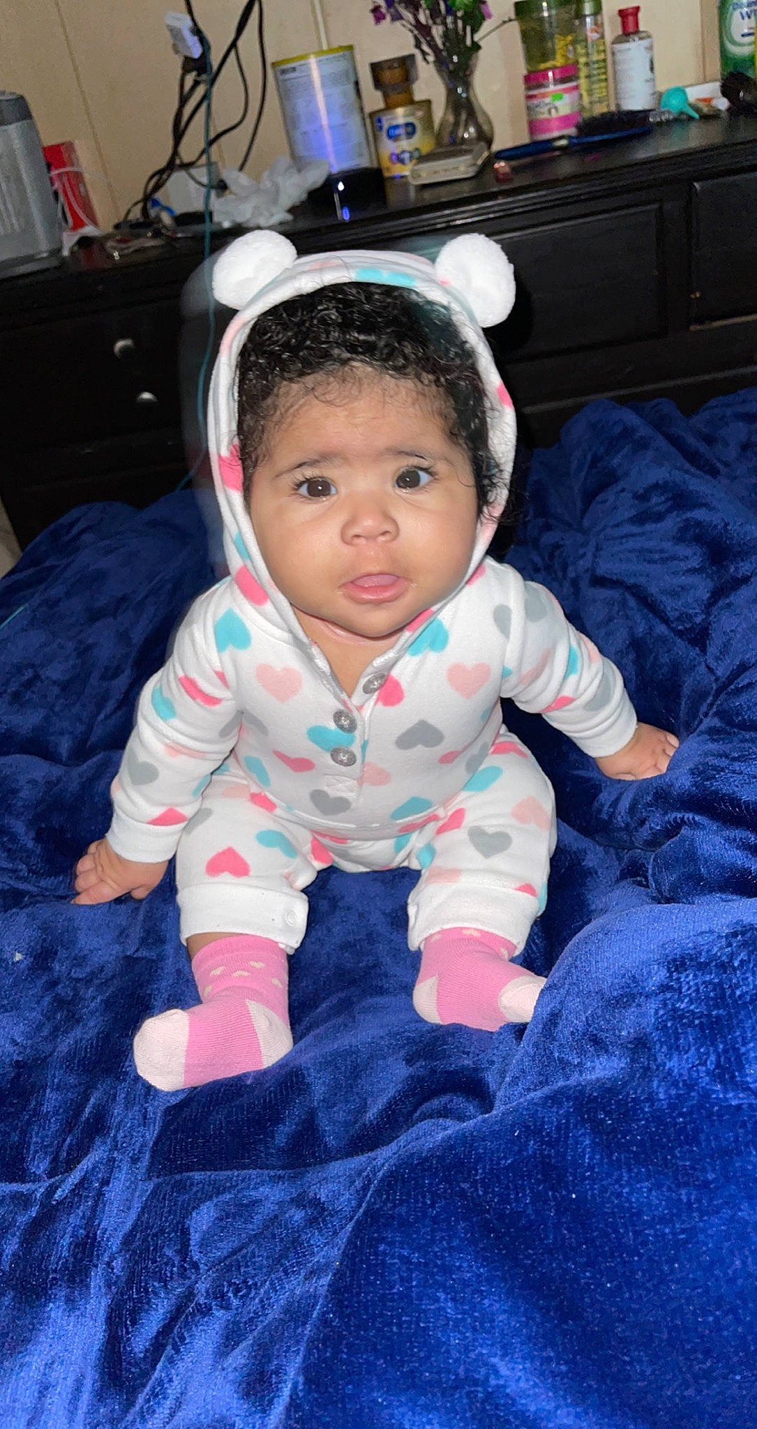 Kylah is registered to the contest to win money with this photo: baby, baby_toddler_clothing, cabinetry, chest, chest_of_drawers, child, comfort, drawer, hair_accessory, headband, mouth, overall, person, sock, toddler