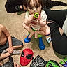 baby, black_panther_mask, captain_america_mask, carpet, casual_clothing, chair, child, children, green_toy, hulk_mask, indoors, pacifier, playroom, playtime, portrait, sitting, spiderman_mask, superhero_masks, toddler, toy