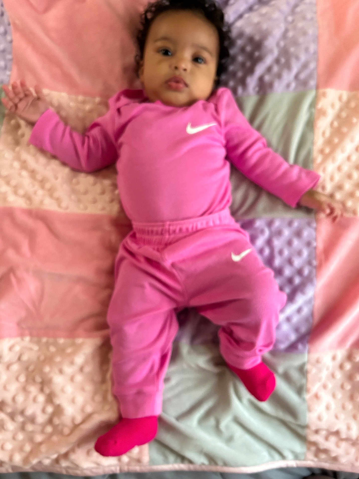 Nasya joined the competition — help win amazing prizes! baby, child, pink_clothing, nike_logo, blanket, pastel_colors, curly_hair, socks, infant, lying_down, soft_texture, cute, portrait, indoors, comfort, toddler, face, person, sleepwear, resting