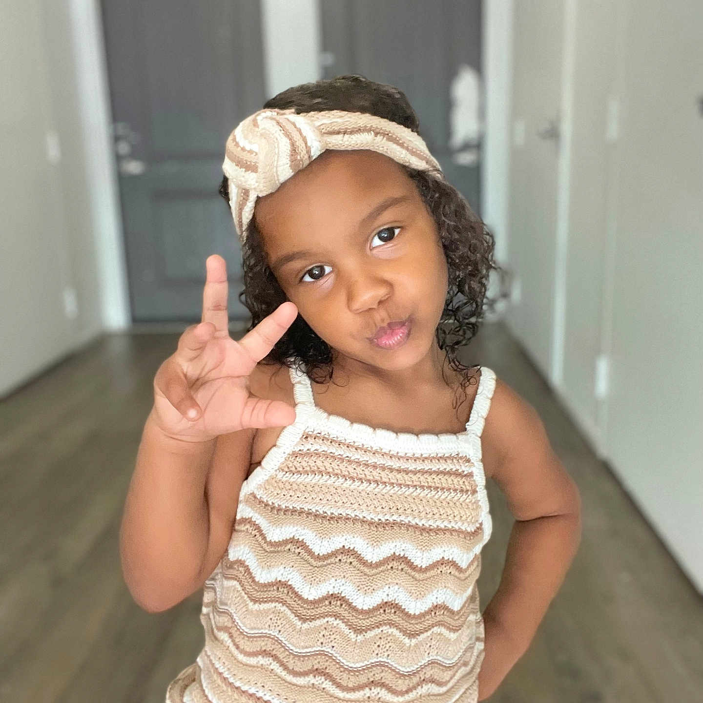 Devyn joined the competition — help win amazing prizes! casual, child, confident, curly_hair, cute, door, fashion, girl, hallway, hand_gesture, headband, indoors, knitted_dress, person, portrait, pose, pout, smile, wooden_floor, young