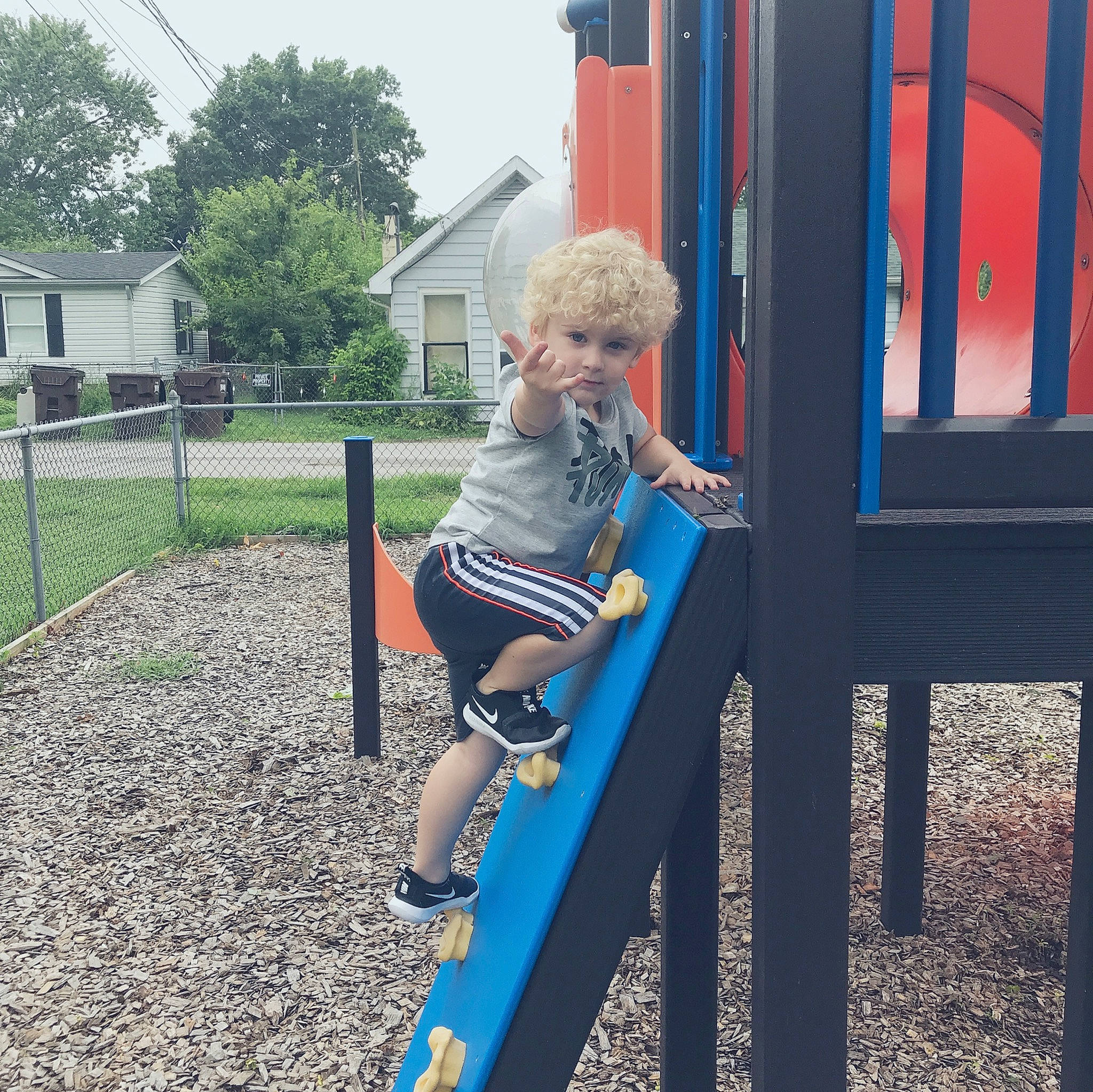 Keon is registered to the contest to win money with this photo: blond, child, chute, city, denim, footwear, fun, headwear, human_settlement, leisure, outdoor_play_equipment, person, plant, play, playground, playground_slide, public_space, recreation, sitting, summer