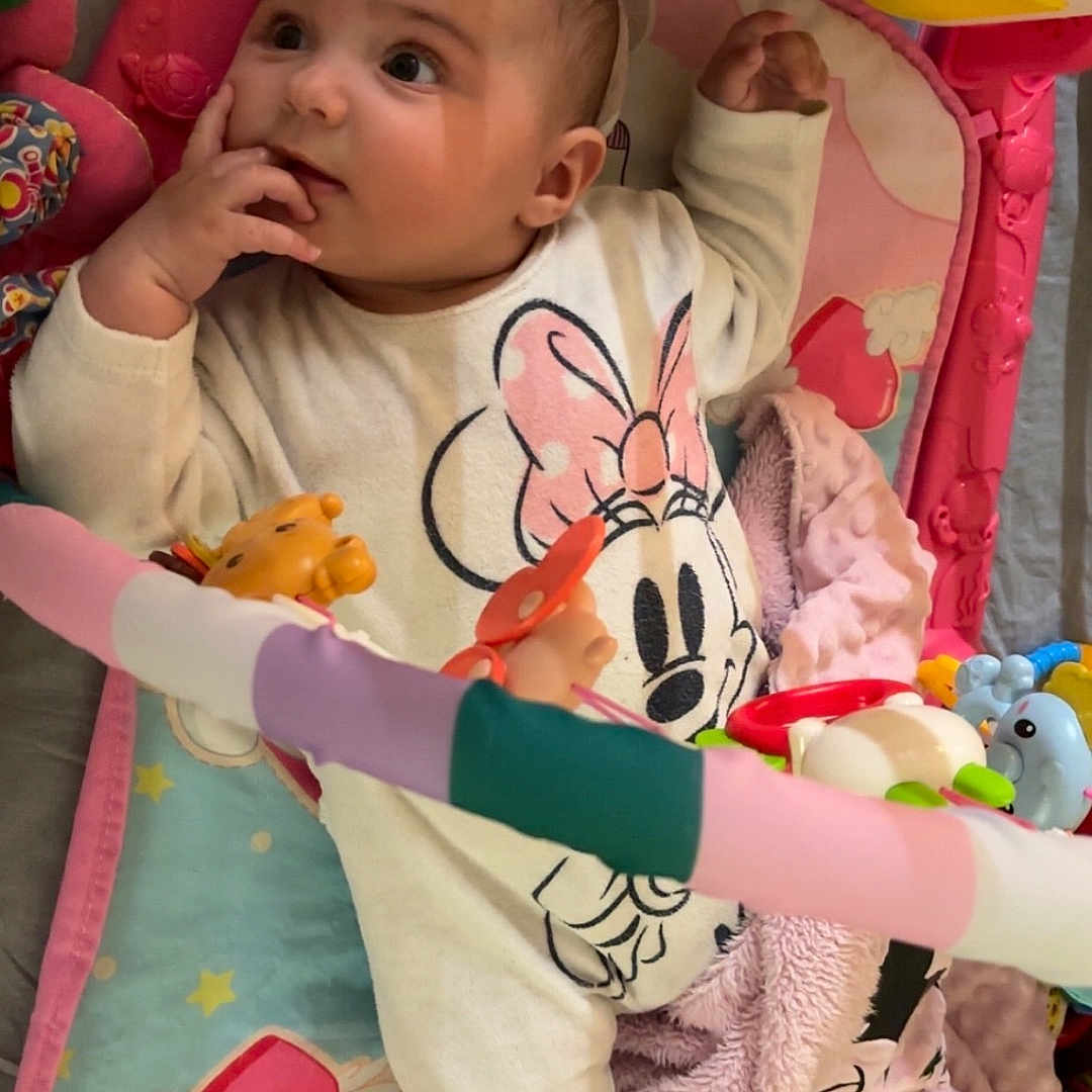Inayha a rejoint le concours — aidez-le/la à gagner de superbes lots ! baby, blanket, child, colorful, cozy, curious, cute, expression, face, floor, hand, indoor, infant, lying_down, minnie_mouse, onesie, pink, play_gym, soft_toy, toy