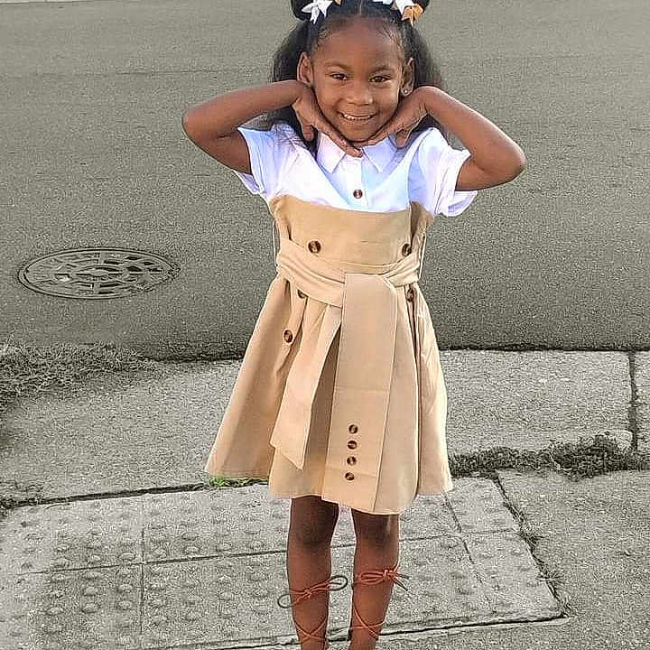 Gabrielle is registered to the contest to win money with this photo: blackhair, child, clothing, coat, face, female, footwear, girl, hair, happy, head, person, photography, portrait, sandal, skirt, sleeve, smile, standing, student