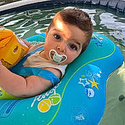 Loann participe au concours pour gagner de l'argent avec cette photo : baby, blue, child, face, float, infant, inflatable_ring, outdoor, pacifier, person, play, pool, relaxation, starfish, summer, sunlight, water, water_toy, yellow, young_child
