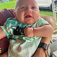 Dallas Ray Jr. joined the competition — help win amazing prizes! baby, child, person, infant, tie_dye_shirt, holding, arm, outdoor, grass, car, vehicle, watch, tattoo, face, expression, clothing, casual, skin, portrait, cute
