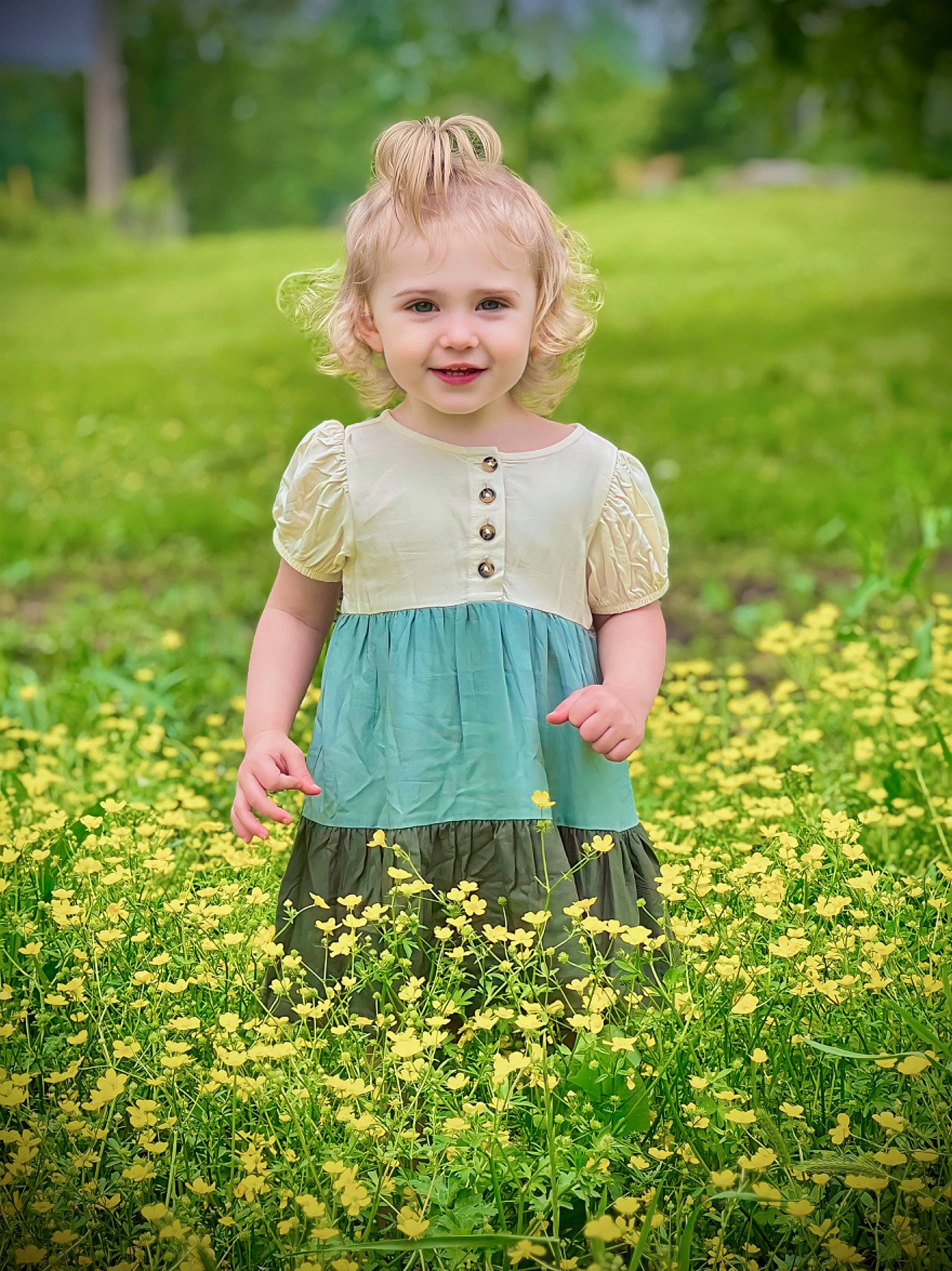 Olivia is registered to the contest to win money with this photo: baby_toddler_clothing, blond, botany, child, dress, flower, grass, grassland, green, hair, hairstyle, happy, joy, meadow, people_in_nature, person, petal, plant, sleeve, smile