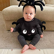 Tommy joined the competition — help win amazing prizes! baby, child, spider_costume, headband, black_clothing, carpet, couch, indoor, cute, blue_eyes, sitting, portrait, costume, baby_feet, plush, person, home, funny, expression, soft_lighting