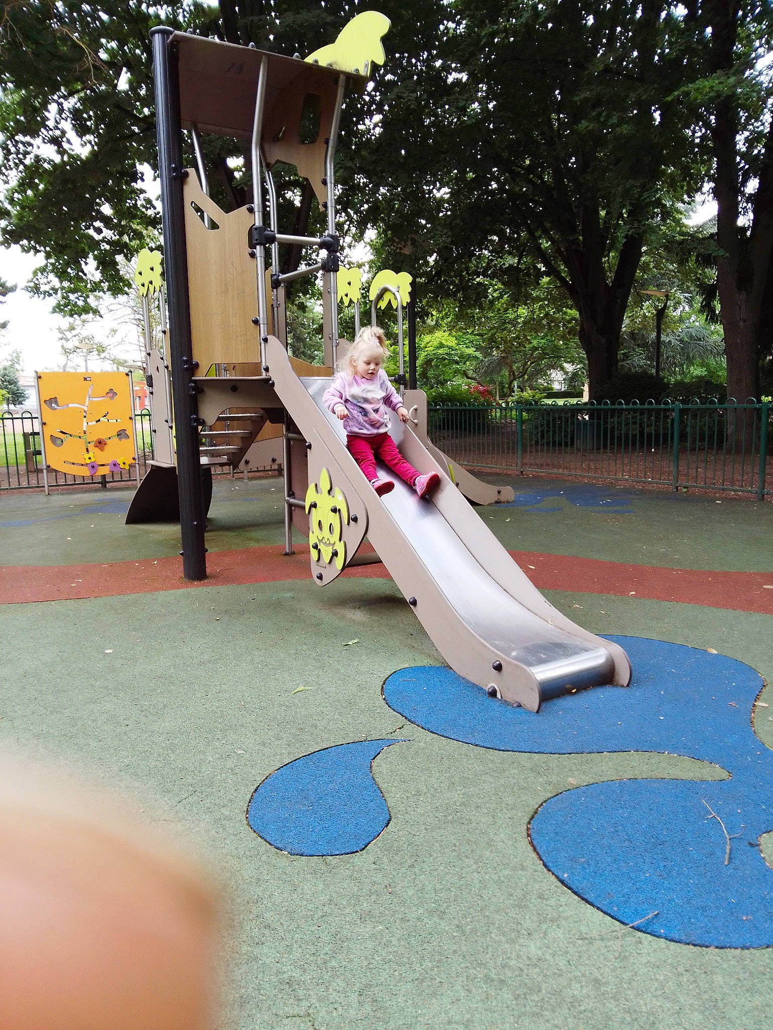 Maylina participe au concours pour gagner de l'argent avec cette photo : asphalt, chute, city, flooring, fun, grass, leisure, outdoor_play_equipment, person, play, playground, playground_slide, recreation, road_surface, shade, soil, swing, tree