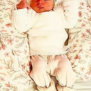 Lola a rejoint le concours — aidez-le/la à gagner de superbes lots ! baby, bow, child, cozy_clothing, cute, face, floral_pattern, fuzzy_slippers, headband, indoors, infant, lying_down, newborn, pillow, pink_pants, portrait, resting, soft_texture, warm, white_sweater