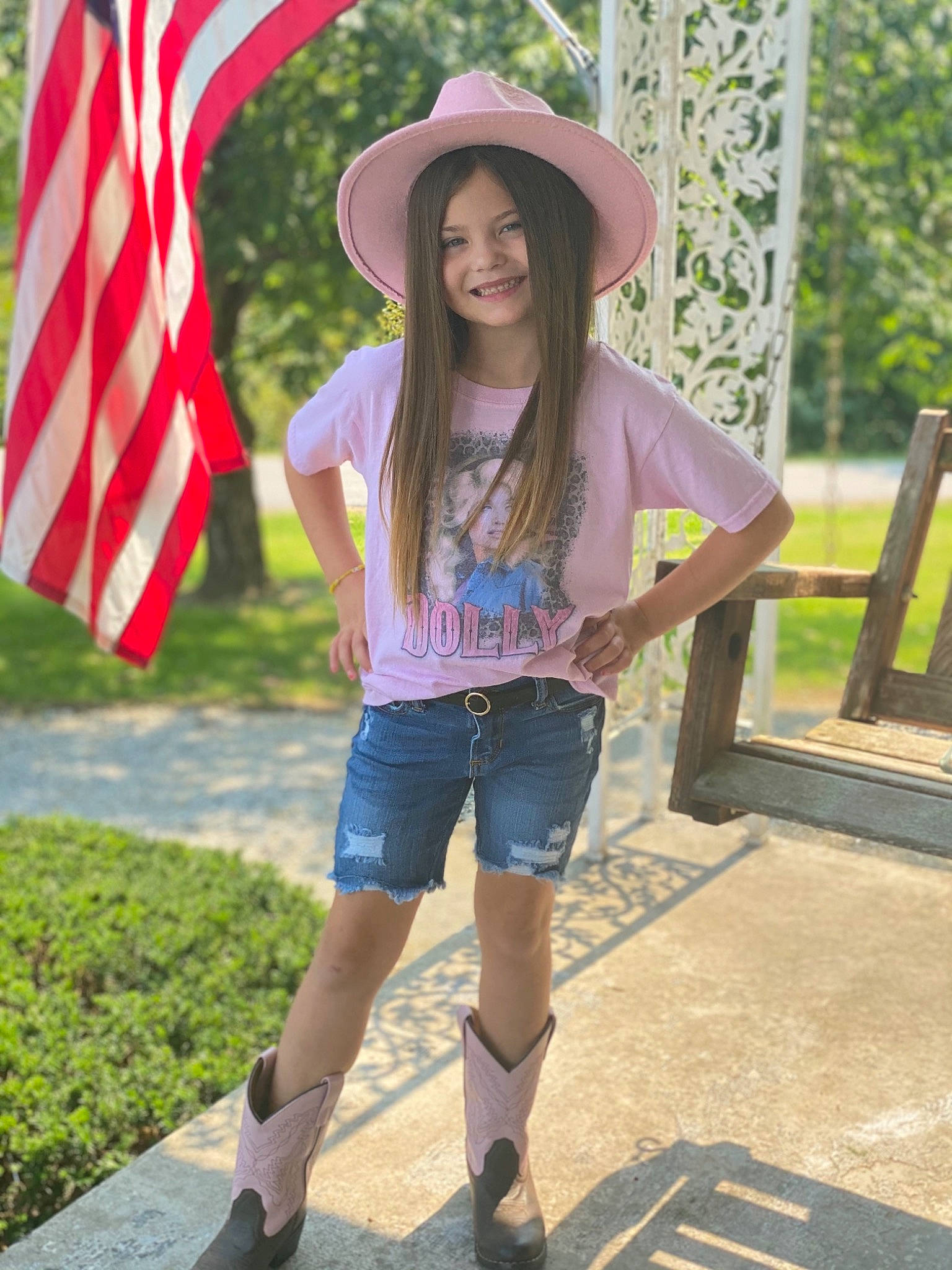 Adilyn is registered to the contest to win money with this photo: clothing, eyewear, face, flag, footwear, grass, hat, jeans, joy, leisure, outerwear, person, photograph, shorts, sleeve, smile, street_fashion, sun_hat, sunglasses, t_shirt