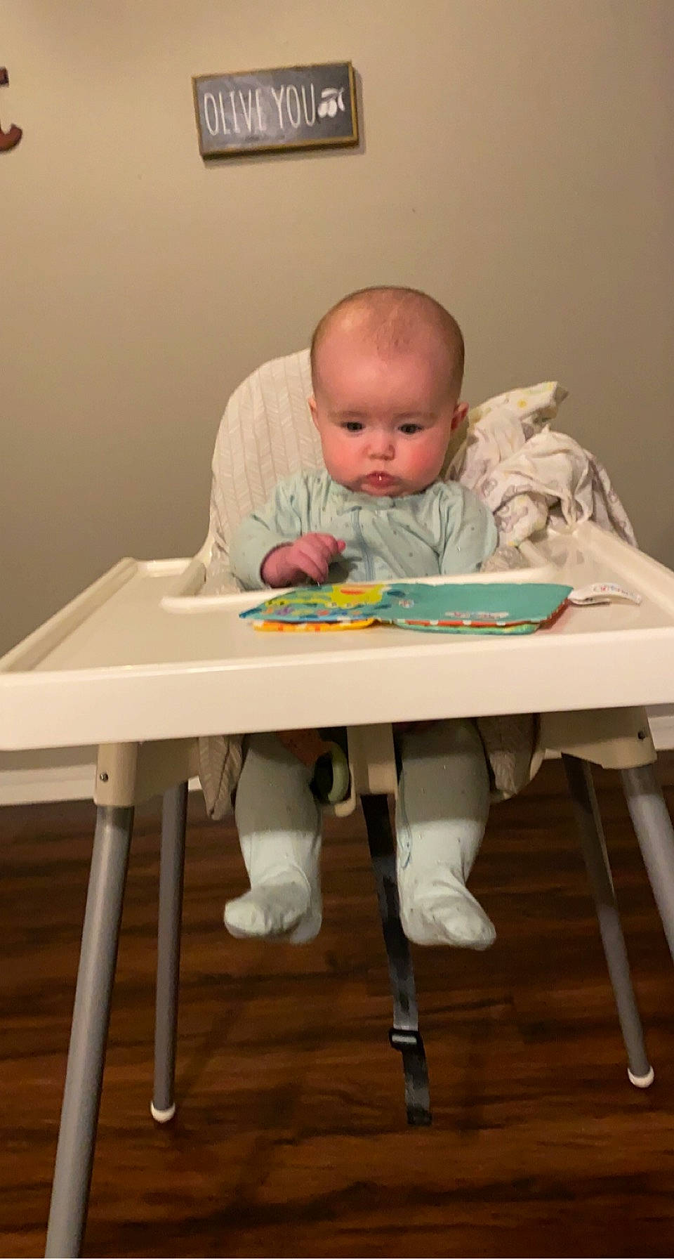 Maisie is registered to the contest to win money with this photo: baby, baby_products, baby_toddler_clothing, chair, child, comfort, flooring, fun, furniture, hardwood, human_body, leisure, person, picture_frame, room, sitting, sleeve, t_shirt, table, toddler