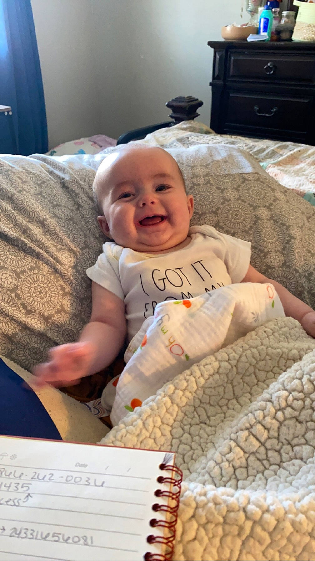 Maisie is registered to the contest to win money with this photo: baby, baby_toddler_clothing, cabinetry, chest_of_drawers, child, comfort, couch, drawer, event, flooring, fun, happy, linens, pattern, person, room, sitting, smile, t_shirt, toddler