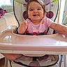 Maya participe au concours pour gagner de l'argent avec cette photo : baby, high_chair, smile, happy, indoor, child, face, furniture, pink_shirt, teeth, hair, seatbelt, home, window, light, foot, arm, table, polka_dot, infant