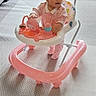 toddler, baby_walker, pink_clothing, indoor, carpet, child, toy, walker, floor, curious, person, footwear, furniture, living_room, window, home, play, baby, standing, young_child