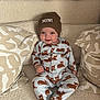 baby, child, infant, smile, beanie, onesie, animal_print, couch, pillows, plush_toys, cozy, indoor, soft_texture, cute, sitting, happy, face, headwear, patterned_clothing, comfortable