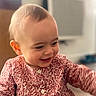 baby, child, smile, happy, face, clothing, patterned_dress, indoor, person, infant, cute, portrait, young_child, head, expression, skin, eyes, mouth, hair, buttoned_dress