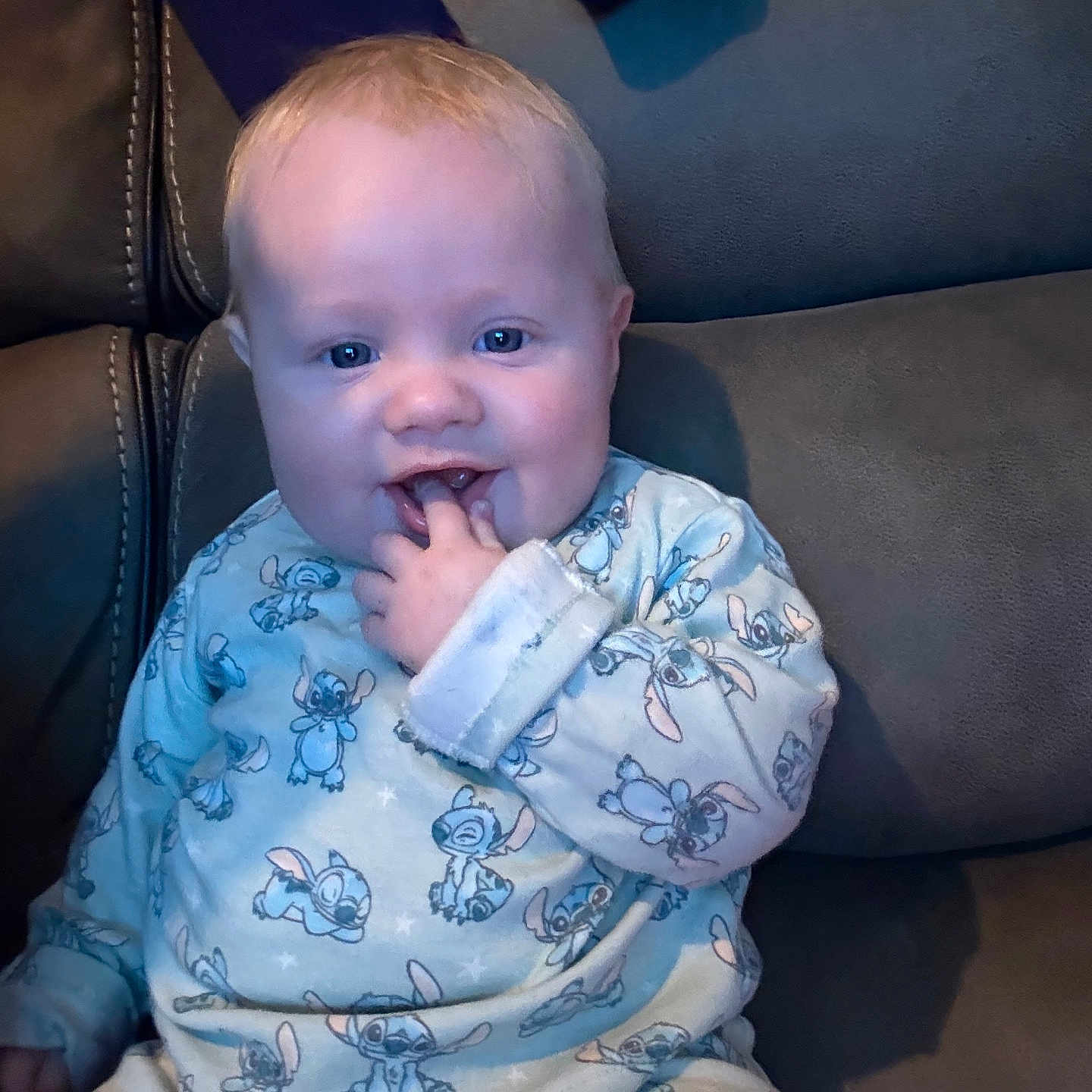 Tyde joined the competition — help win amazing prizes! baby, blue_eyes, child, clothing, comfort, couch, cozy, cute, face, fingers_in_mouth, happy, indoor, infant, leather, pajamas, person, sitting, smiling, stitch_pattern, young_child