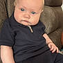 baby, child, infant, blue_eyes, blonde_hair, navy_outfit, zipper, sitting, couch, leather_couch, curious, chubby_cheeks, indoor, portrait, casual_clothing, young_child, person, hand, face, expression