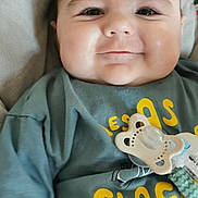 Simon participe au concours pour gagner de l'argent avec cette photo : baby, blanket, casual, child, closeup, clothing, cute, face, green_shirt, happy, indoors, infant, pacifier, person, portrait, sitting, smiling, soft, toddler, young_child