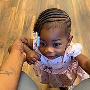 Amiyah is registered to the contest to win money with this photo: toddler, child, braids, beads, hand_holding, pink_dress, smile, indoors, wooden_floor, curious, joyful, person, cute, fashion, footwear, parent, family, skin, portrait, young_child