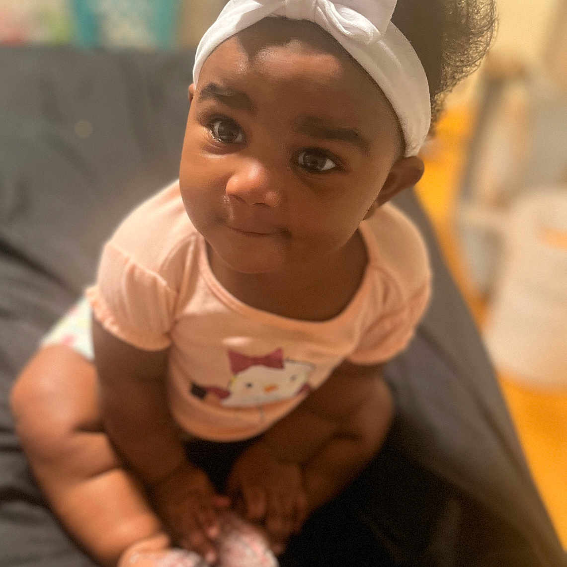 Lyrik is registered to the contest to win money with this photo: accessories, baby, blackhair, bodypart, clothing, couch, face, finger, furniture, hand, happy, head, headband, indoors, person, photography, portrait, shorts, sitting, smile
