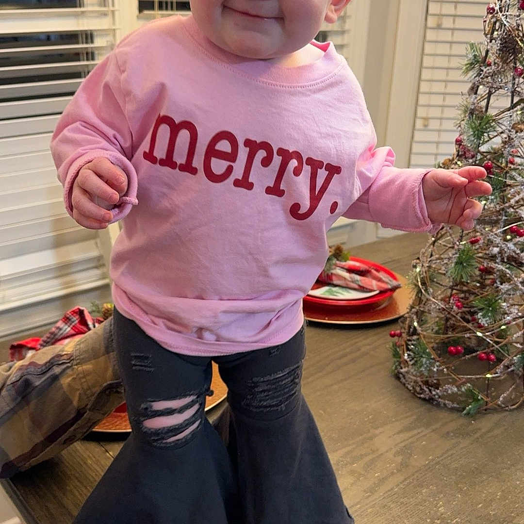 Vivie is registered to the contest to win money with this photo: accessories, baby, clothing, electronics, face, footwear, furniture, glasses, head, pants, person, phone, photography, plant, portrait, pottedplant, shoe, t_shirt, table, wood