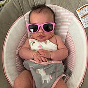 Seylah joined the competition — help win amazing prizes! baby, baby_accessory, baby_seat, child, clothing, cool, cute, fashion, hands, indoors, infant, infant_clothing, person, pink, portrait, relaxing, seat, small_child, sunglasses, unicorn