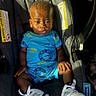 baby, blond_hair, blue_clothing, car_interior, car_seat, casual_wear, child, daylight, footwear, infant, interior, portrait, safety, seatbelt, serious_expression, sitting, sneakers, sunlight, toddler, young_child