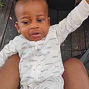 Christopher joined the competition — help win amazing prizes! arm_raised, baby, child, cuddles, curious, cute, expression, face, glass_table, indoor, infant, lap, onesie, person, sitting, snuggle, table, text_print, white_clothing, wooden_floor