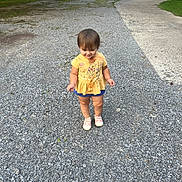 Delilah joined the competition — help win amazing prizes! toddler, child, gravel, driveway, yellow_shirt, winnie_the_pooh, shorts, shoes, parked_cars, trees, house, outdoor, daylight, smiling, dirty_clothes, person, cute, young_child, standing, suburban