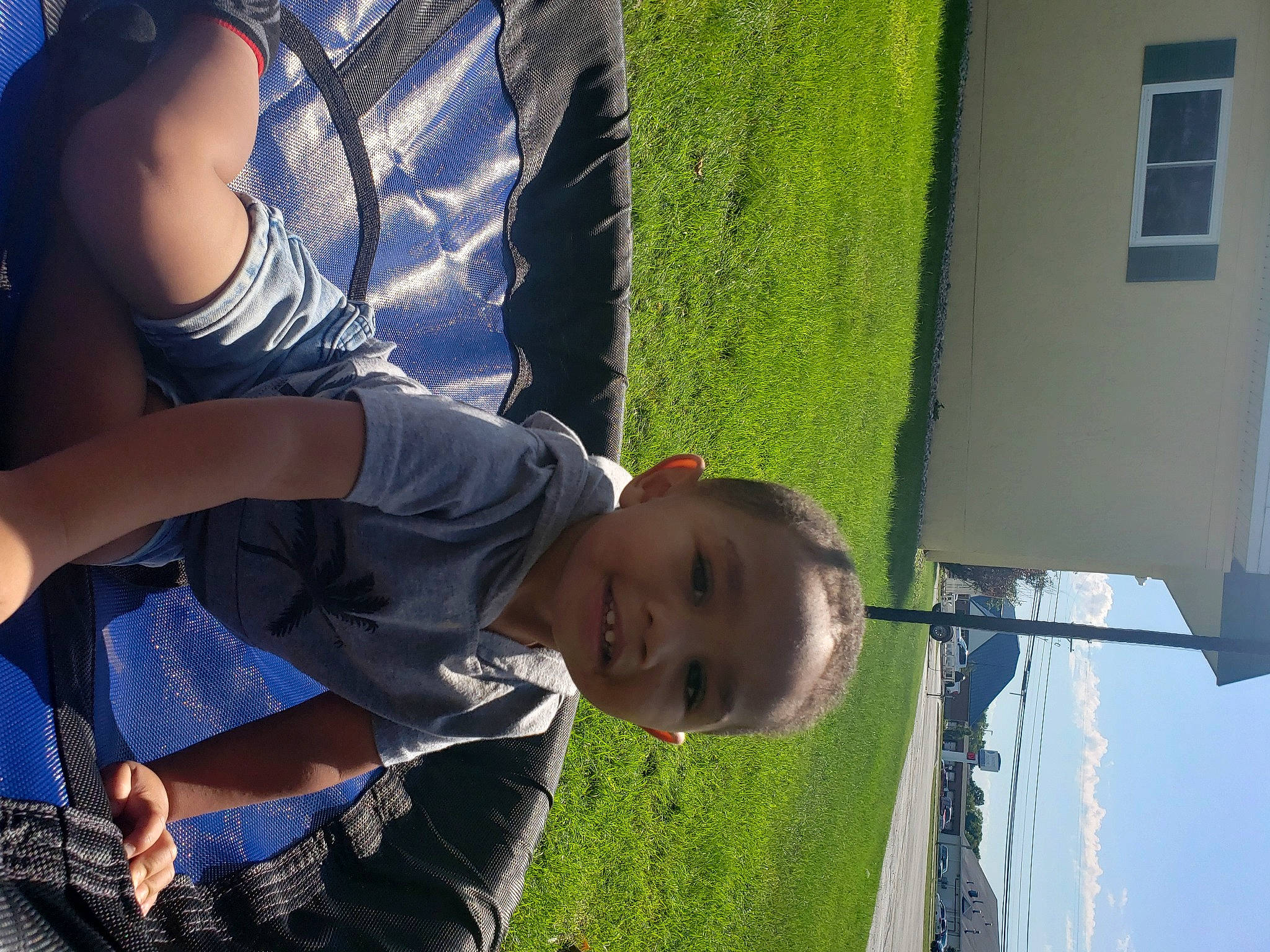 Trayvon is registered to the contest to win money with this photo: blue, child, elbow, fun, gesture, grass, happy, joy, leg, leisure, people_in_nature, person, photograph, plant, smile, summer, t_shirt, toddler, tree, white