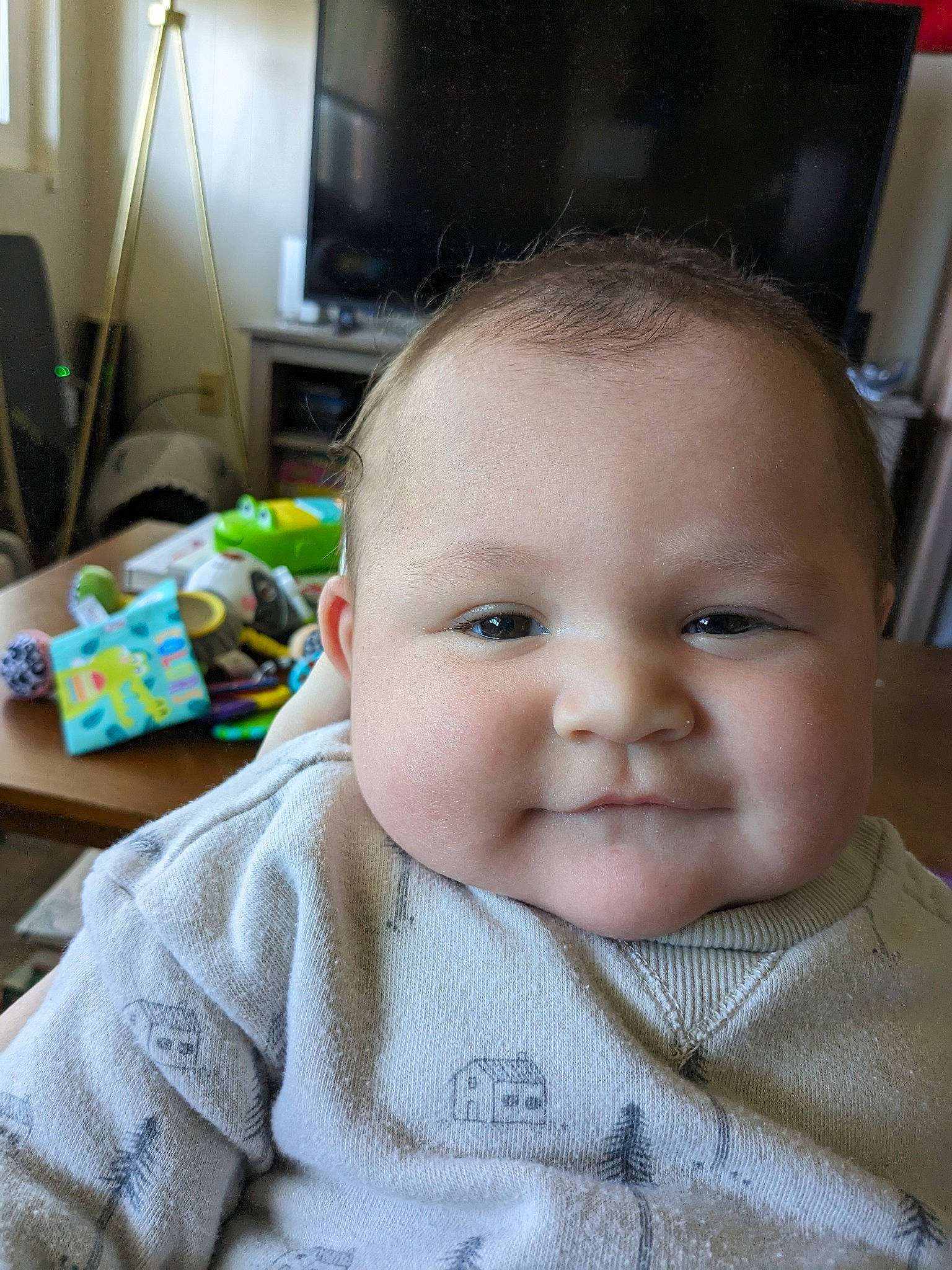 Isaac is registered to the contest to win money with this photo: baby, baby_toddler_clothing, cheek, child, eyelash, iris, joy, lamp, led_backlit_lcd_display, nose, person, sitting, skin, sleeve, television, toddler, woolen