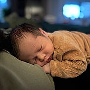Andy participe au concours pour gagner de l'argent avec cette photo : baby, sleeping, infant, cozy, brown_clothing, close_up, soft_texture, indoors, peaceful, resting, head, face, child, portrait, sleep, newborn, warm_lighting, blurred_background, cute, calm