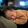 baby, sleeping, infant, cozy, brown_clothing, close_up, soft_texture, indoors, peaceful, resting, head, face, child, portrait, sleep, newborn, warm_lighting, blurred_background, cute, calm