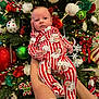 Stetson joined the competition — help win amazing prizes! baby, christmas_tree, ornaments, holiday, festive, red, white, green, lights, person, infant, onesie, santa_claus, decoration, hands, celebration, indoor, seasonal, cute, portrait