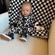 Stetson joined the competition — help win amazing prizes! baby, child, couch, plush_toy, blanket, checkered_pattern, black_and_white, footwear, sitting, indoors, cute, portrait, clothing, toy, furniture, person, infant, expression, fabric, soft_toy