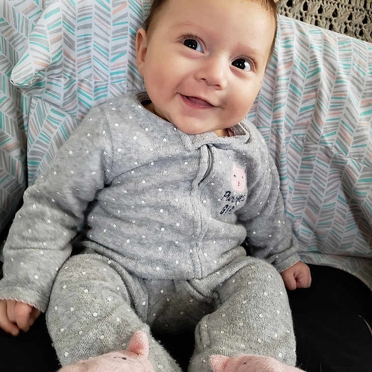 Vivienne is registered to the contest to win money with this photo: arm, baby, baby_toddler_clothing, cheek, child, head, person, sitting, skin, sleeve, smile, toddler