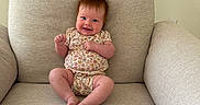 Ember joined the competition — help win amazing prizes! baby, child, infant, smiling, sitting, chair, cushion, onesie, floral_pattern, hair, happy, indoors, face, cute, skin, feet, arms, legs, person, furniture
