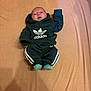baby, infant, adidas, clothing, hoodie, pants, socks, bed, sheet, lying_down, cute, child, young, fashion, portrait, indoor, person, apparel, casual, sporty