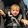 Kylo is registered to the contest to win money with this photo: baby, baby_trend_brand, black_clothing, blue_eyes, casual, child, cute, happy, harness, indoor, infant, light_hair, person, portrait, safety_strap, seat, smiling, stroller, toddler, young_child