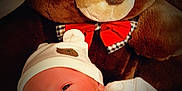 Emiliano a rejoint le concours — aidez-le/la à gagner de superbes lots ! baby, newborn, infant, teddy_bear, plush_toy, hat, onesie, red_bow, cute, soft_toy, child, face, sleepy, cozy, indoors, portrait, comfort, warm, resting, closeup