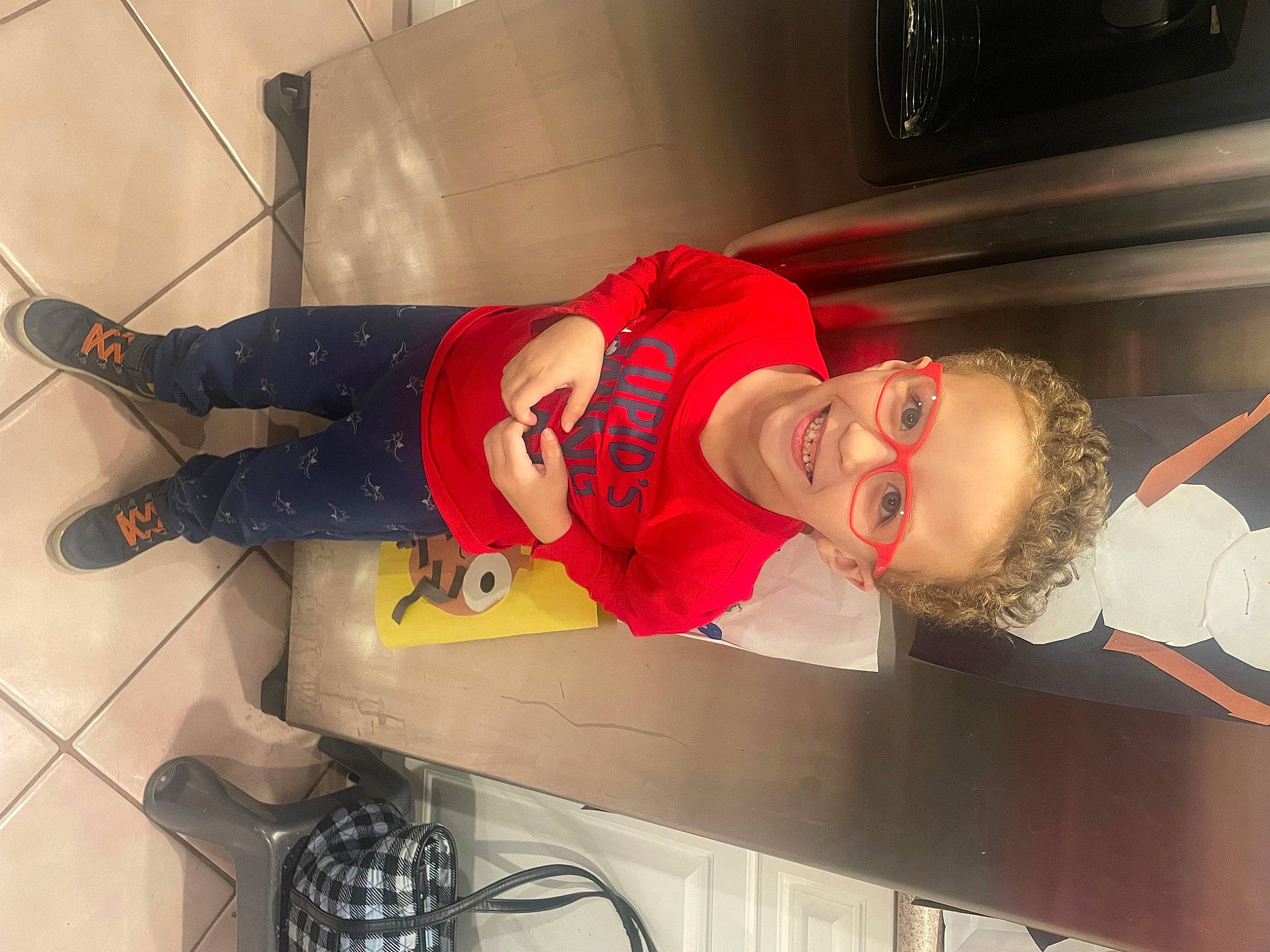 Zachary is registered to the contest to win money with this photo: carmine, child, cooking, flooring, fun, hat, joy, knee, person, room, smile, sportswear, t_shirt, table, toddler, walking_shoe
