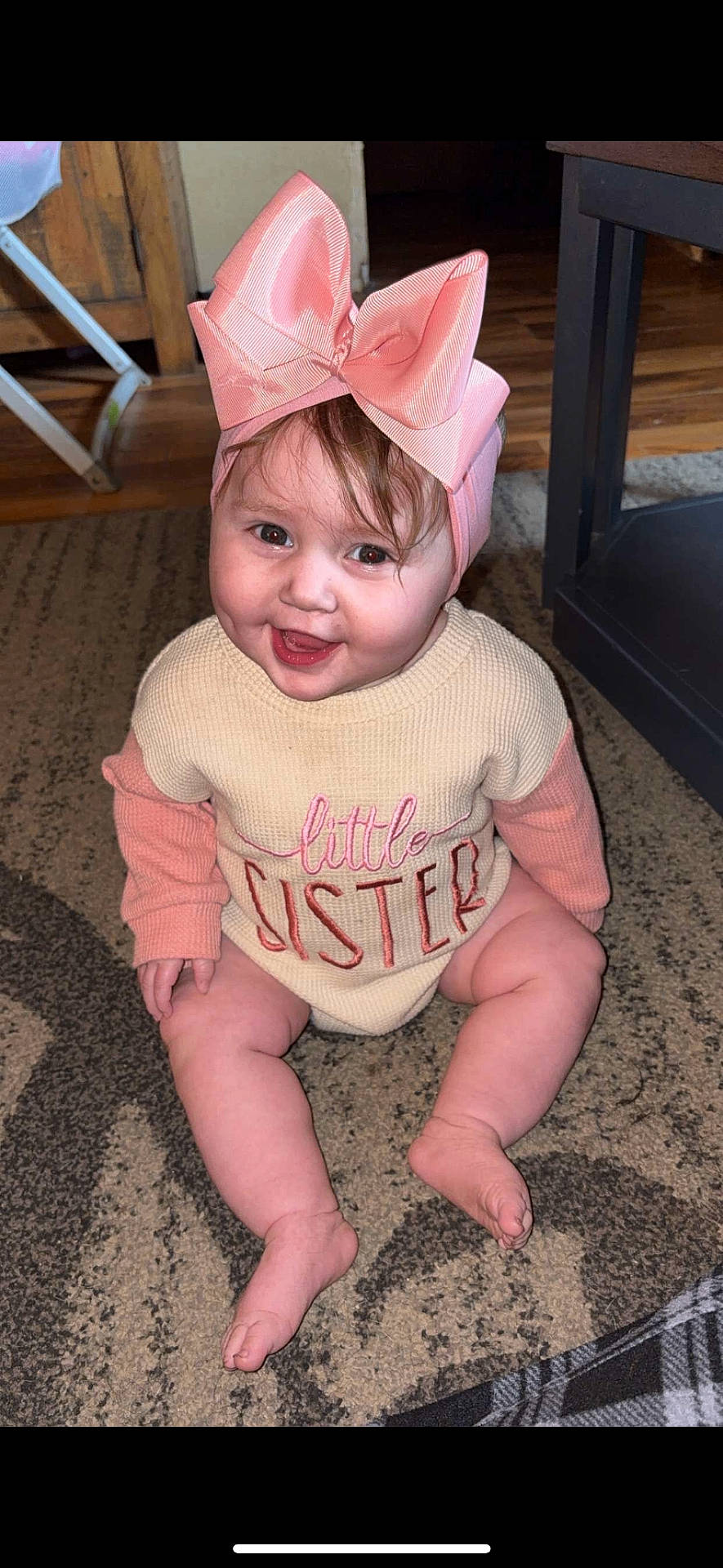 Evelynn is registered to the contest to win money with this photo: baby, bow, candid, carpet, child, clothing, cute, floor, happy, headband, home, indoor, infant, person, pink, portrait, sitting, smiling, sweater, young_child