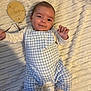 baby, infant, smile, blue_checkered_overalls, white_long_sleeve_shirt, socks, soft_blanket, wooden_sign, two_months, lying_down, cute, child, portrait, indoors, happy, face, hands, feet, cozy, newborn