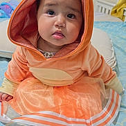 Luna joined the competition — help win amazing prizes! baby, child, orange_costume, hood, ears, bed, blanket, blue, pattern, tulle_skirt, socks, cute, indoor, portrait, toddler, face, expression, soft, home, cozy