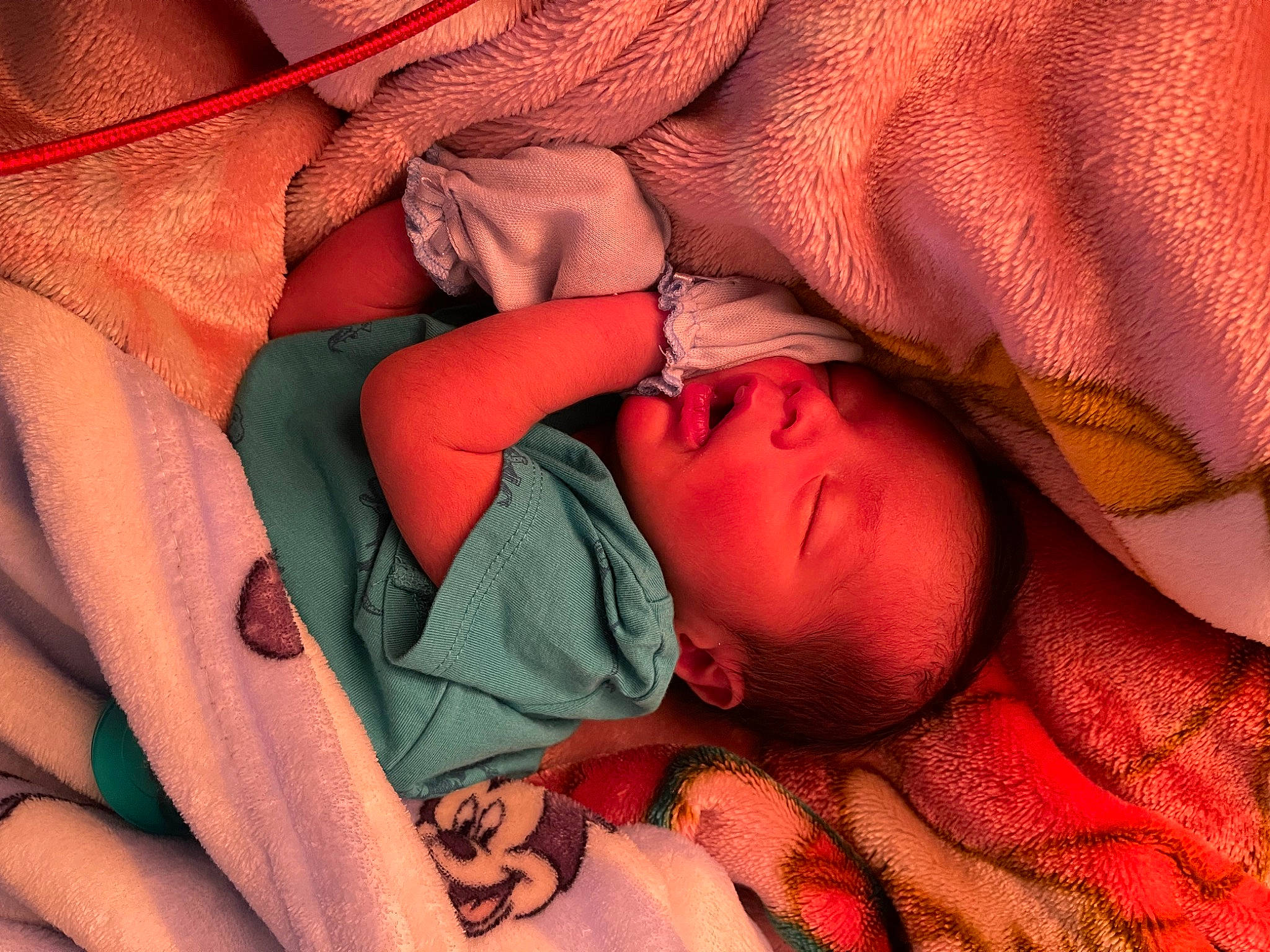 Adrian is registered to the contest to win money with this photo: arm, baby, bed, carmine, comfort, eyelash, finger, human_body, linens, lip, mouth, muscle, nail, orange, pattern, peach, person, pink, red, textile