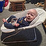 baby, infant, smiling, baby_rocker, cushion, carpet, chair, footwear, slippers, clothing, indoor, person, happy, relaxing, home, furniture, baby_garment, head, face, small_child