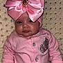 baby, pink_outfit, headband, bow, sparkle, blanket, cute, infant, portrait, child, clothing, face, hand, sitting, indoor, young_child, soft_texture, cute_expression, adorable, warm_lighting