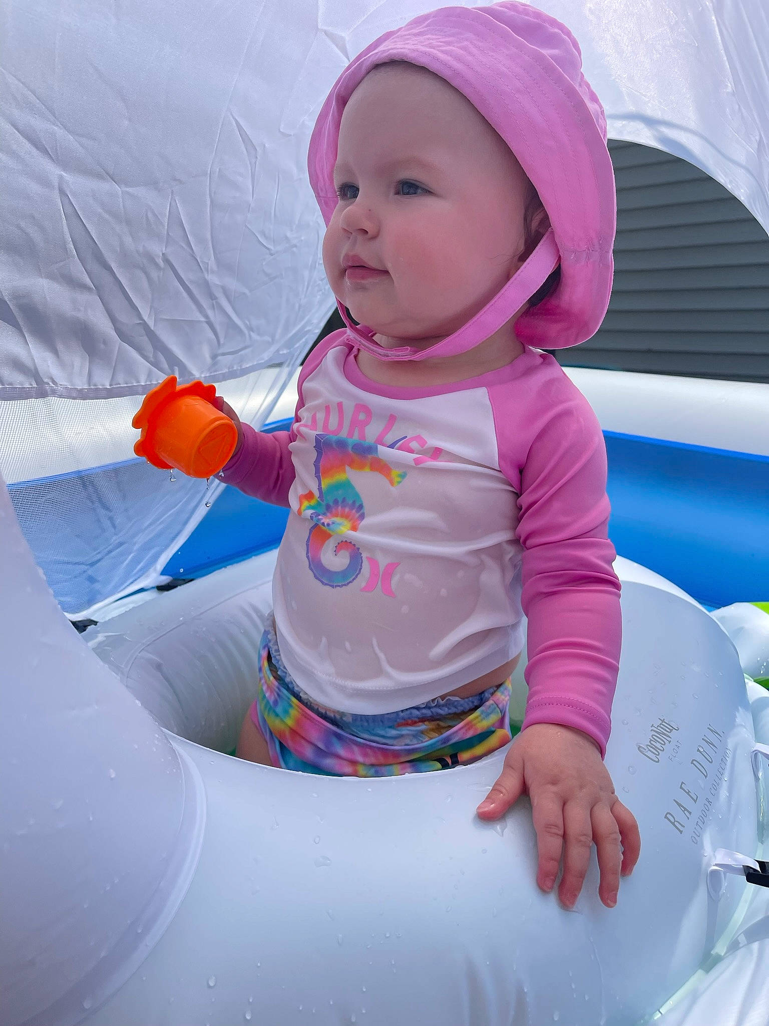 Storie is registered to the contest to win money with this photo: baby, baby_toddler_clothing, cap, child, comfort, electric_blue, fun, happy, headwear, inflatable, leisure, magenta, person, personal_protective_equipment, pink, play, purple, recreation, sitting, sleeve